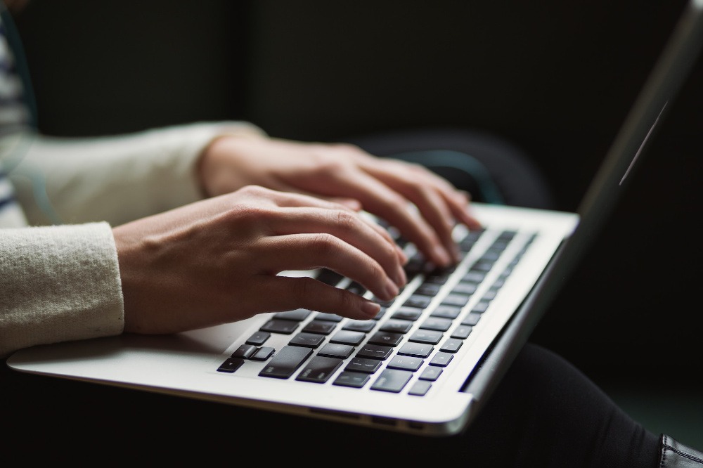 kaitlyn-baker-vZJdYl5JVXY-unsplash-web A woman typing on a computer