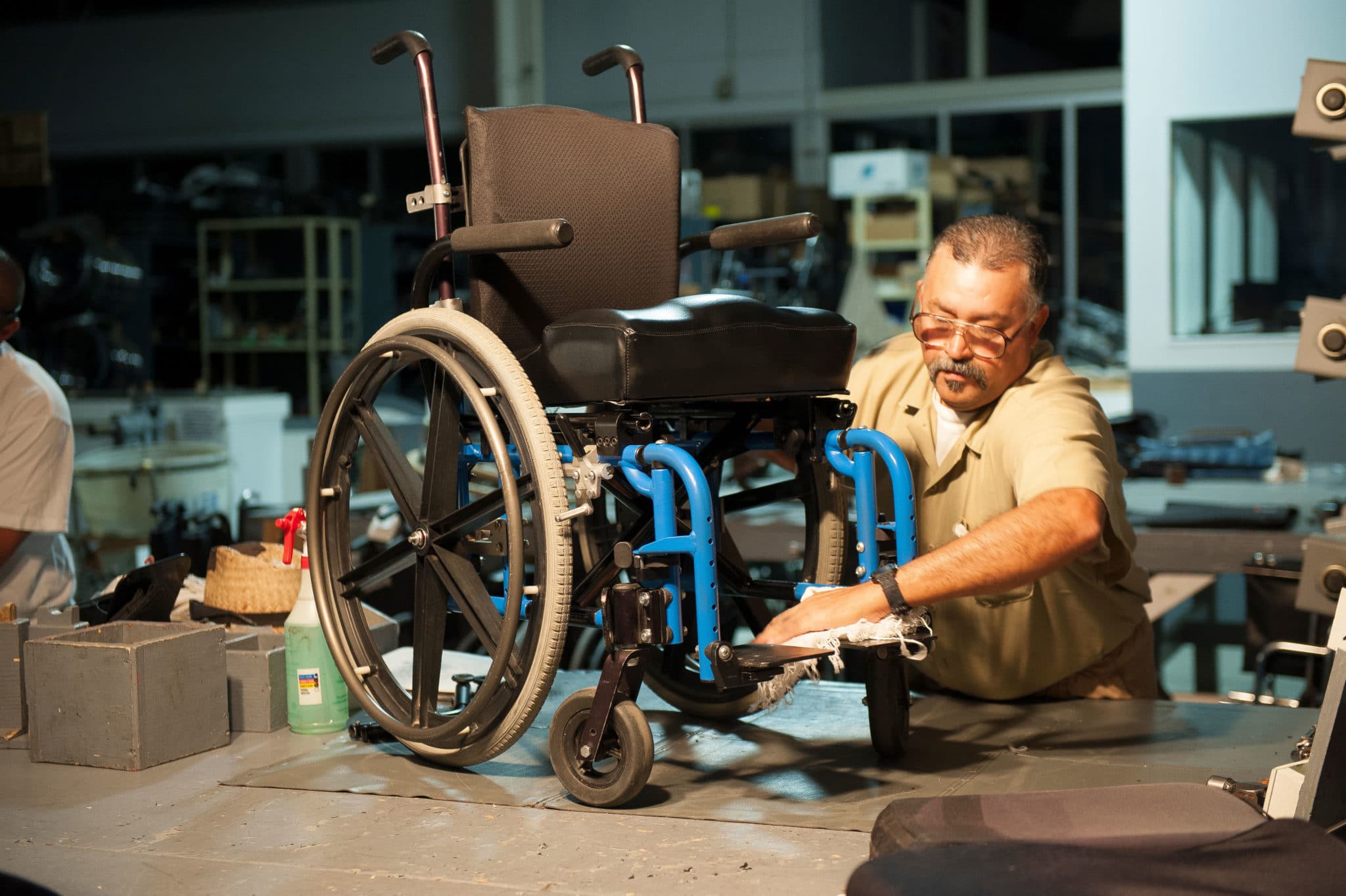 RESTORATION 19 WFTW Chair Corps SoCal 0181 A worker restores a used wheelchair