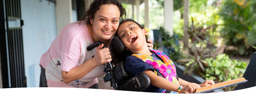 A mother embraces her child in her new wheelchair